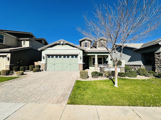 view of front of home featuring a garage, covered porch, and a front lawn