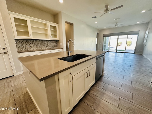 kitchen featuring sink, white cabinets, decorative backsplash, a kitchen island with sink, and stainless steel dishwasher