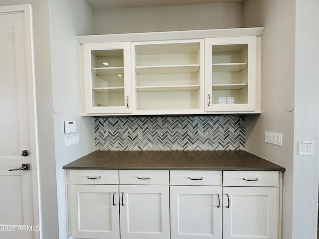 bar with tasteful backsplash and white cabinets