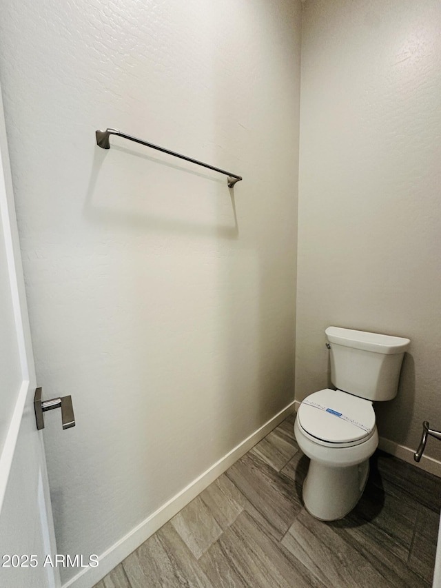 bathroom with hardwood / wood-style floors and toilet