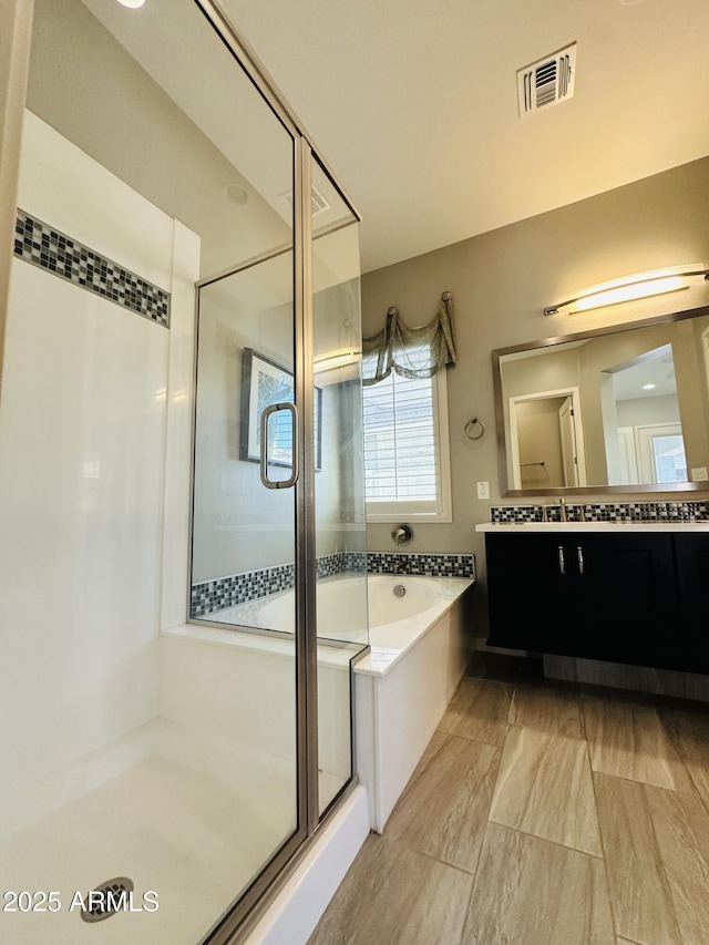 bathroom with independent shower and bath and vanity