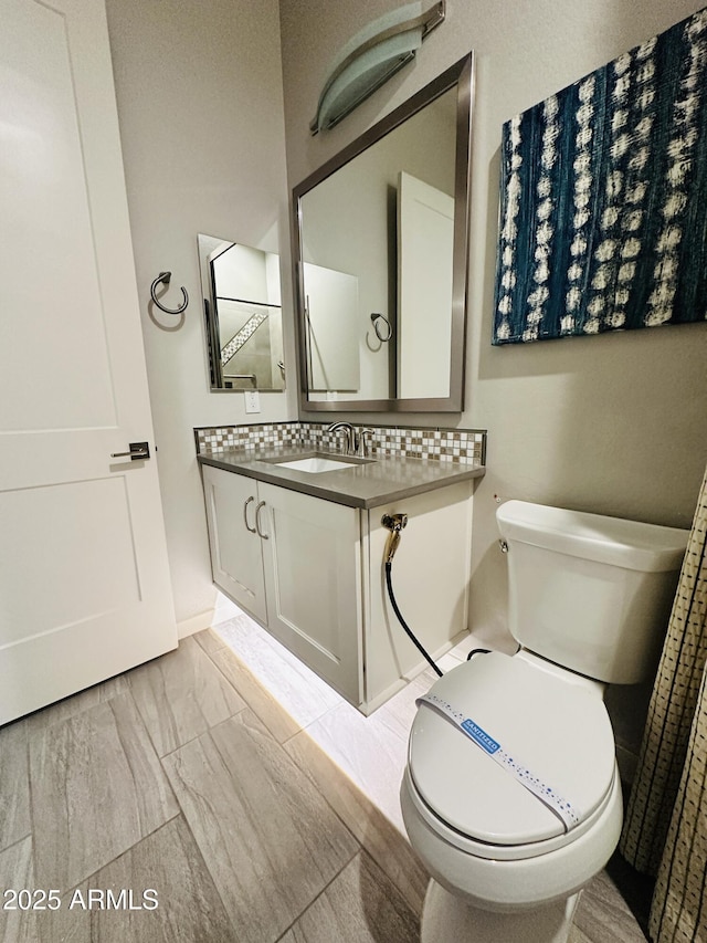 bathroom with tasteful backsplash, sink, and toilet