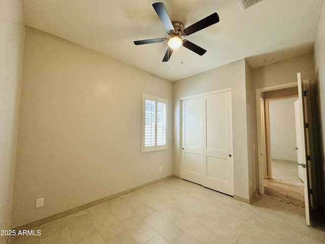 unfurnished bedroom with ceiling fan and a closet