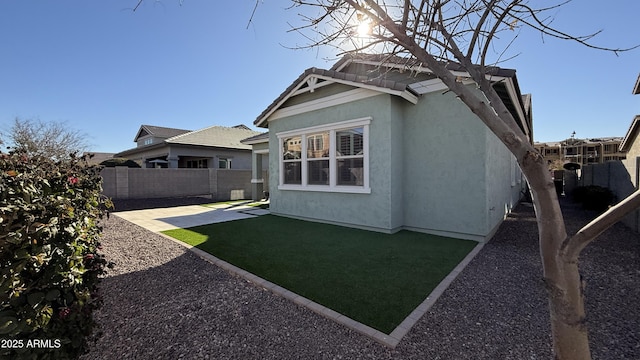 back of house with a patio and a lawn