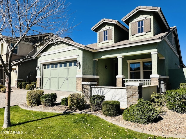 craftsman house featuring a porch, a garage, and a front yard