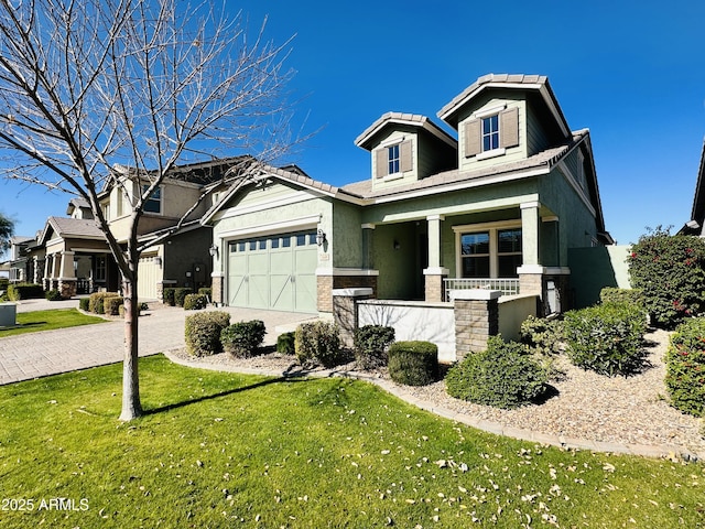 view of front of house featuring a garage, a front yard, and covered porch