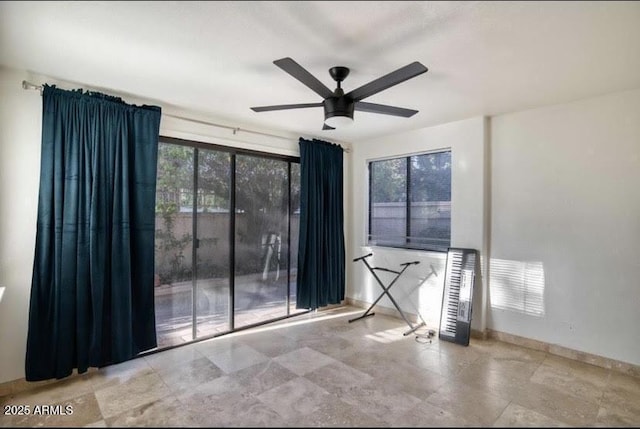 spare room with ceiling fan and plenty of natural light