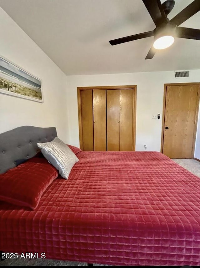 bedroom with ceiling fan, light carpet, and a closet