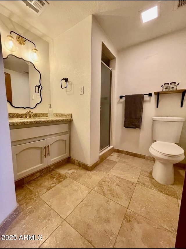 bathroom featuring vanity, toilet, and a shower with door