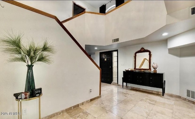 foyer entrance featuring a towering ceiling