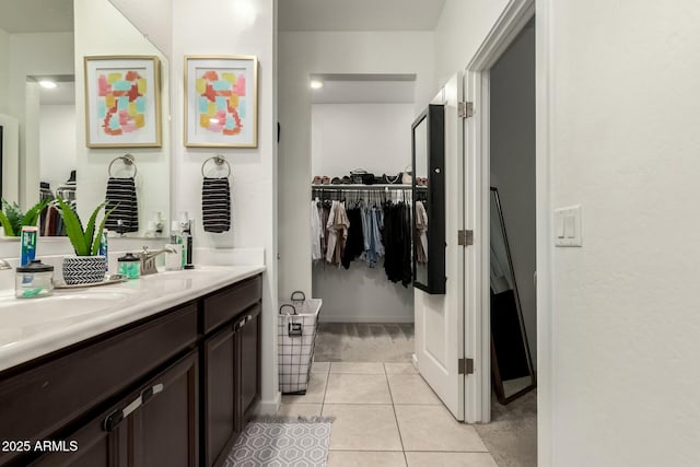 40467 W Jenna Ln, Maricopa, AZ 85138 - bathroom with a spacious closet, baseboards, double vanity, tile patterned floors, and a sink