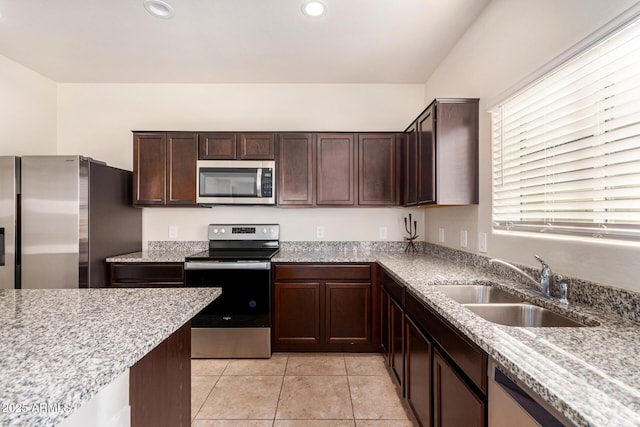 kitchen featuring sink, light tile patterned floors, dark brown cabinets, and appliances with stainless steel finishes