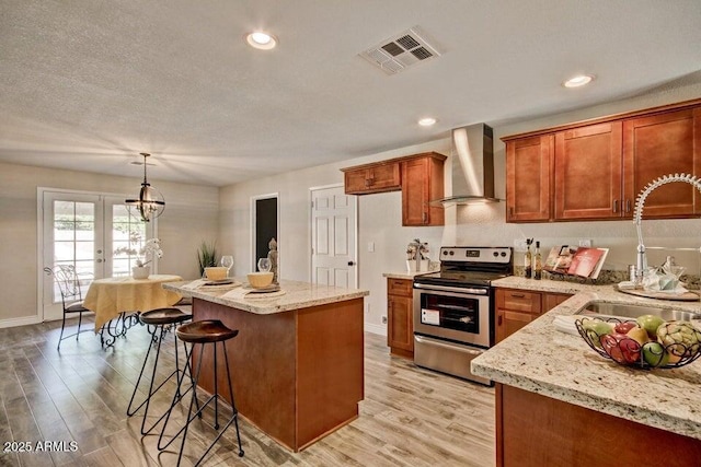 1045 S Solomon St, Mesa, AZ 85204 - kitchen featuring wall chimney range hood, stainless steel range with electric cooktop, a sink, light wood-style floors, and recessed lighting
