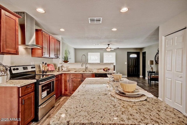 1045 S Solomon St, Mesa, AZ 85204 - kitchen featuring stainless steel electric stove, a sink, wall chimney range hood, a ceiling fan, and a peninsula