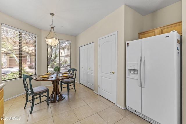 dining space featuring light tile patterned floors, baseboards, and a wealth of natural light