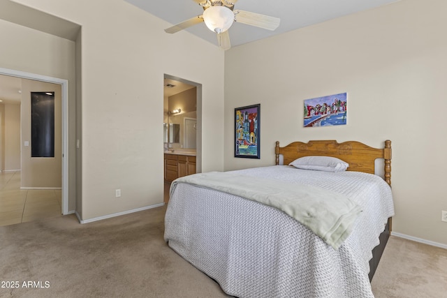 bedroom with light colored carpet, baseboards, ensuite bathroom, and ceiling fan