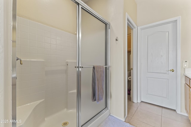 bathroom with vanity, tile patterned flooring, baseboards, and a stall shower