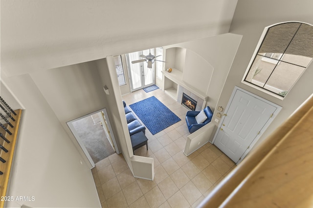 entryway with a ceiling fan, tile patterned floors, and a fireplace