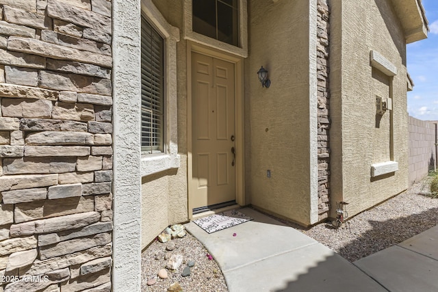 entrance to property with stucco siding and stone siding