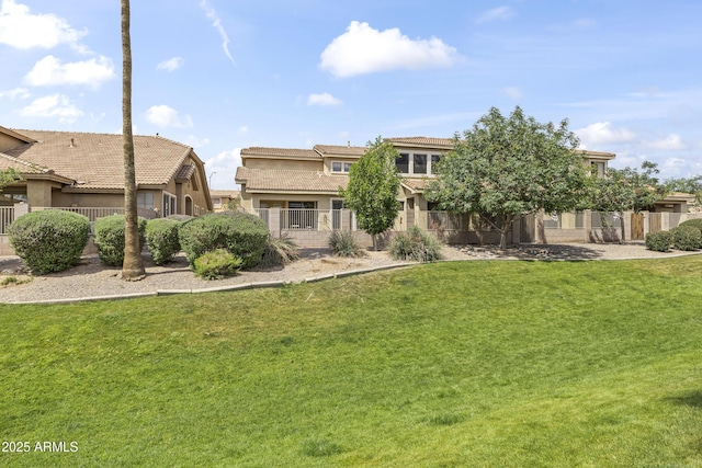 back of property featuring a lawn, fence, stucco siding, and a tile roof