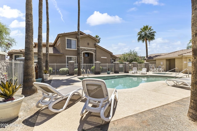 pool with fence and a patio area