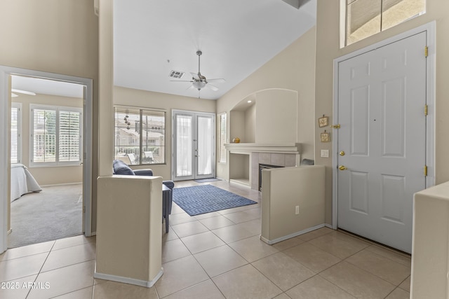 foyer featuring light tile patterned floors, baseboards, a ceiling fan, and a tile fireplace