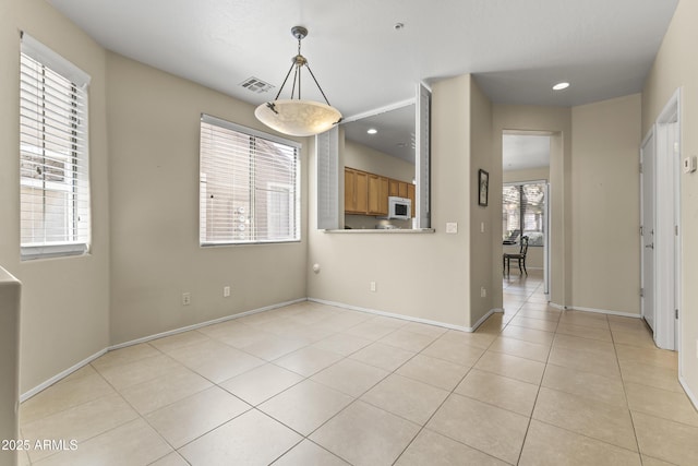 unfurnished dining area featuring baseboards, recessed lighting, and light tile patterned floors