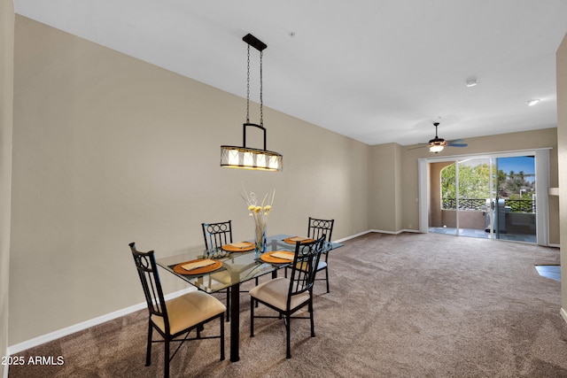 carpeted dining room featuring baseboards and ceiling fan