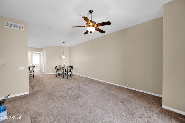 interior space with baseboards, ceiling fan, and visible vents
