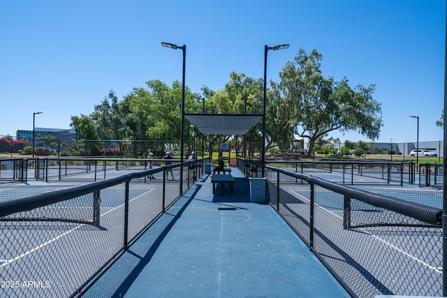 view of tennis court featuring fence