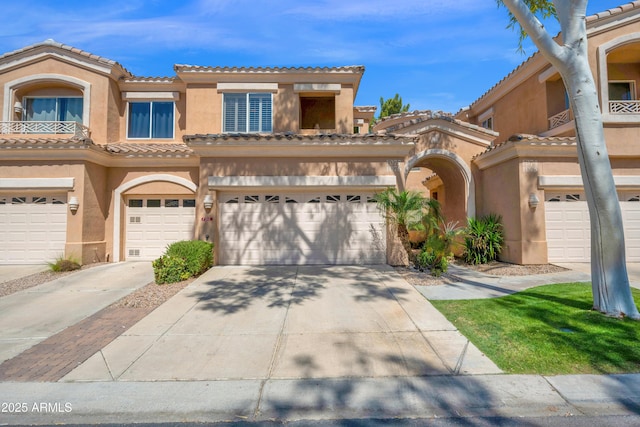 multi unit property featuring concrete driveway, an attached garage, a tile roof, and stucco siding