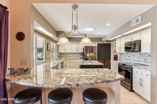 kitchen with sink, kitchen peninsula, hanging light fixtures, and appliances with stainless steel finishes