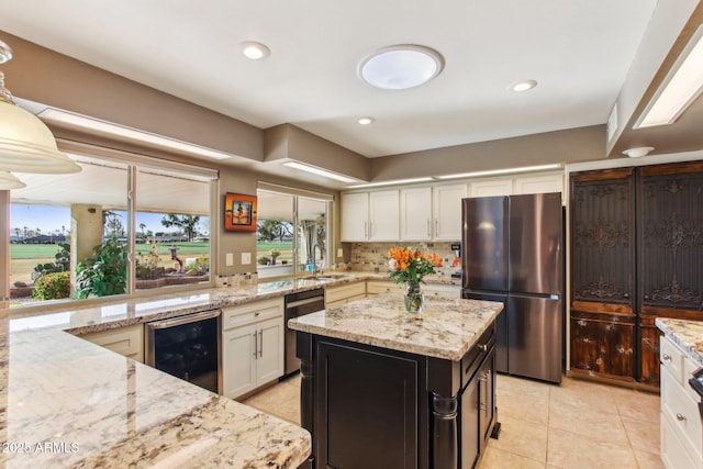 kitchen featuring light stone countertops, stainless steel appliances, wine cooler, and plenty of natural light