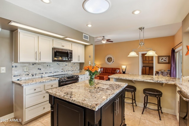 kitchen featuring white cabinetry, light stone countertops, electric stove, and tasteful backsplash