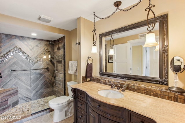 bathroom featuring a tile shower, vanity, tasteful backsplash, and toilet