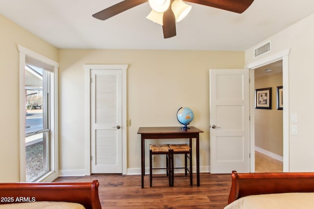 bedroom with multiple windows, dark wood-type flooring, and ceiling fan