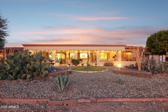 view of back house at dusk