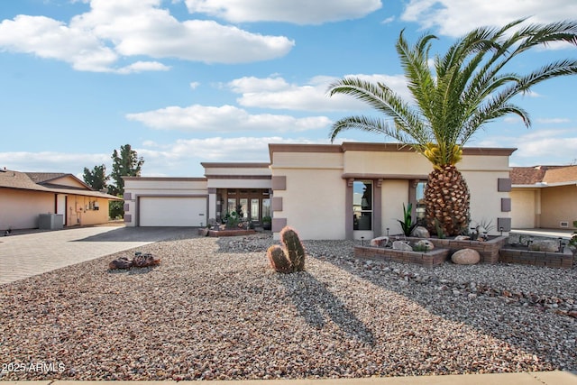 view of front of home featuring a garage and central air condition unit