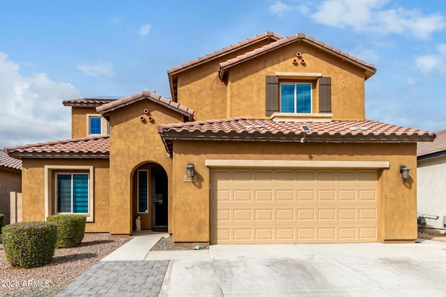 mediterranean / spanish home with a garage, driveway, and stucco siding