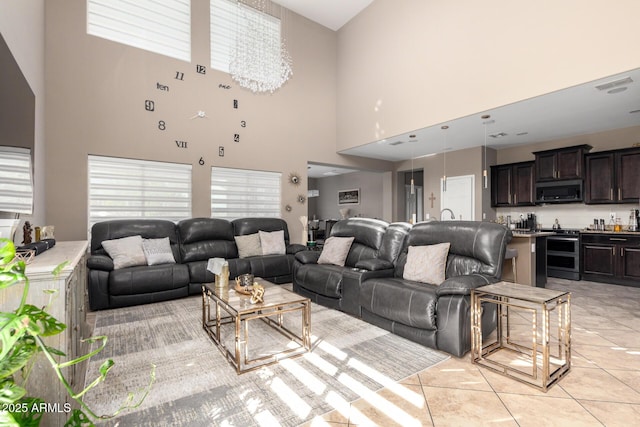 living room featuring light tile patterned floors, visible vents, and a notable chandelier