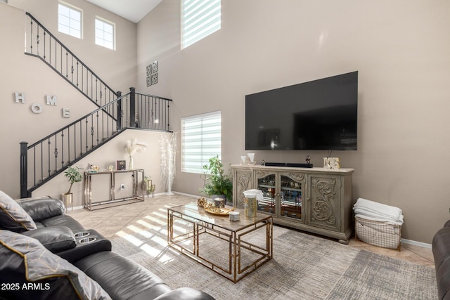 living area with stairs, tile patterned floors, and baseboards