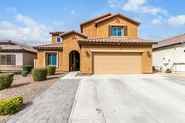 mediterranean / spanish house featuring stucco siding, a garage, driveway, and a tile roof