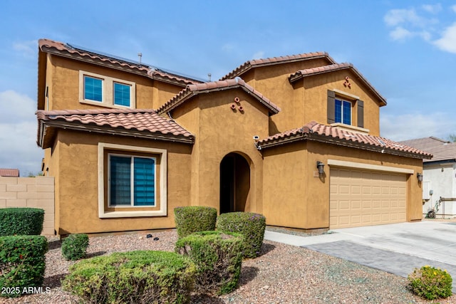 mediterranean / spanish home with an attached garage, fence, a tile roof, stucco siding, and driveway