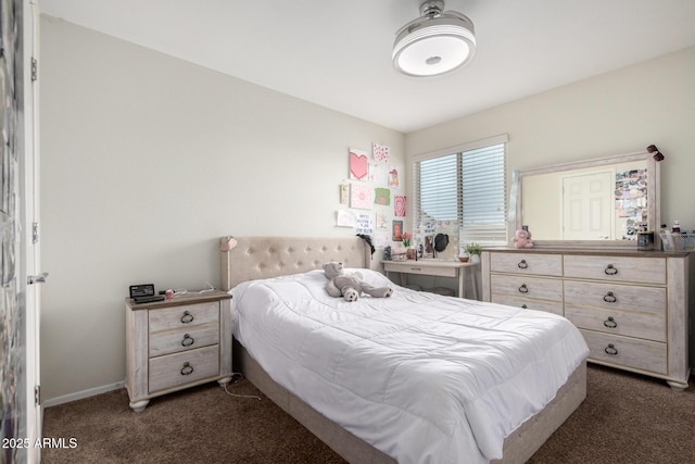 bedroom featuring baseboards and dark carpet