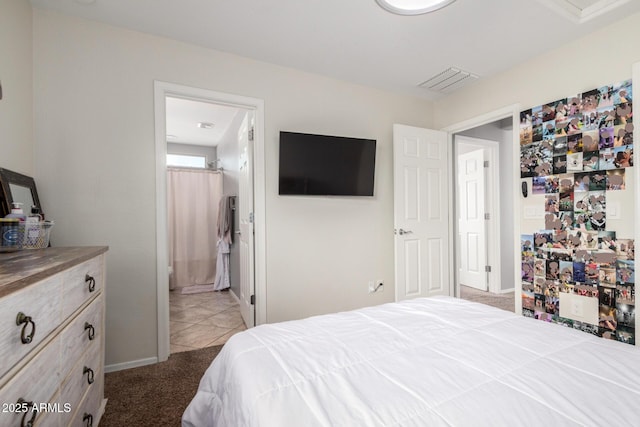 bedroom with connected bathroom, baseboards, visible vents, and light carpet