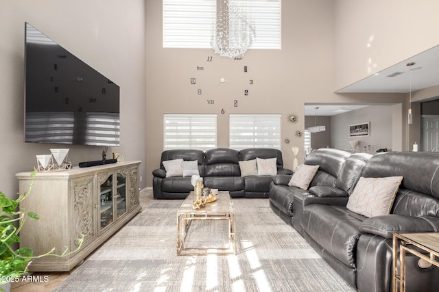 living room featuring visible vents, a healthy amount of sunlight, and a towering ceiling