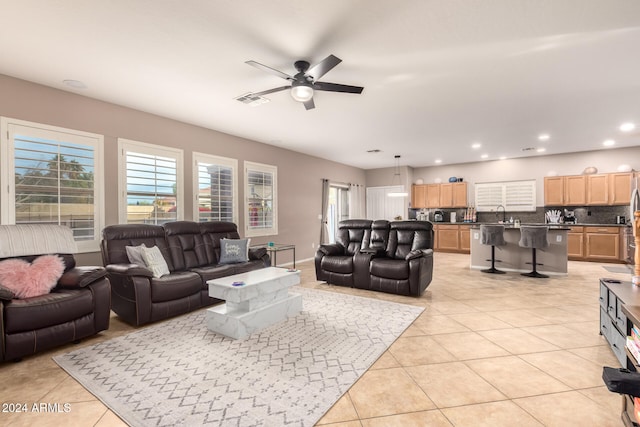 living room with sink, ceiling fan, and light tile patterned flooring