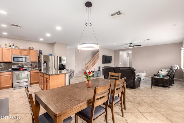 tiled dining room featuring ceiling fan