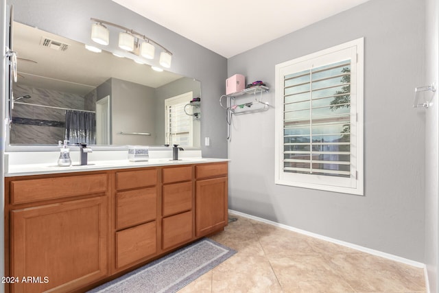 bathroom with a shower with shower curtain, vanity, and tile patterned floors