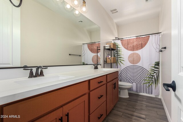 bathroom featuring wood-type flooring, a shower with curtain, vanity, and toilet